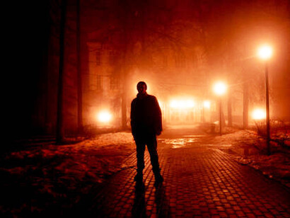 A lone figure strides down a misty alley in the park at night, a symbol of solitude and defiance