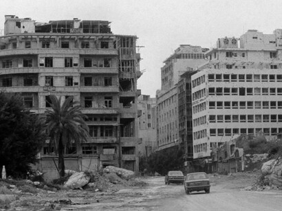 Cars pass a building destroyed by a bomb in Beirut Lebanon. Buildings across the city were targeted during the ongoing confrontation between Lebanese forces and the Palestine Liberation Organization (PLO)