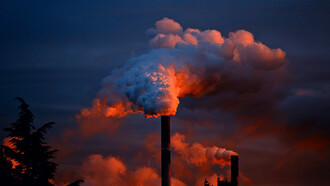 This stark image of factories emitting thick plumes of smoke illustrates the environmental challenges posed by industrialisation, highlighting the urgent need for sustainable practices