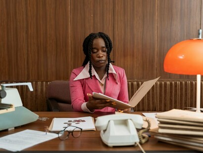 An African executive concentrating on important paperwork, reflecting the changing expectations placed on modern African women