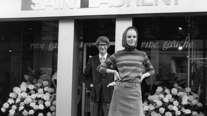 Yves Saint Laurent y una de sus modelos frente a su tienda en la Rive gauche de París