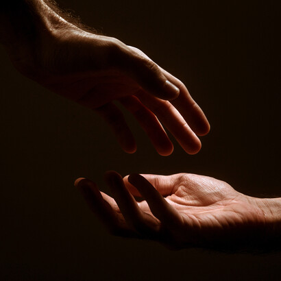 Acercamiento a un par de manos a punto de tocarse