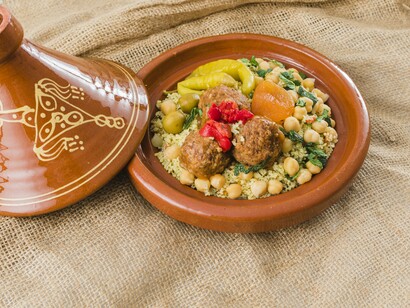 A vibrant spread of regional flavors featuring meatballs, couscous, and vegetables