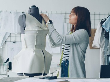 A designer adjusting fabric directly on a dress form, reflecting how sustainable fashion begins with reconsidering the way fabric is shaped and used