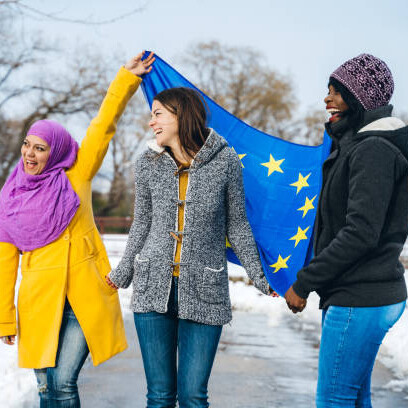 A group of diverse European women symbolizing harmony, equality, and shared identity, gathered in front of the EU flag to represent the spirit of community and inclusion