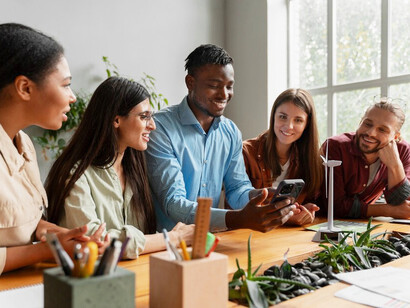 A team collaborates in a bright office space, mapping out a carbon-neutral strategy as part of their company’s journey toward sustainability and innovation