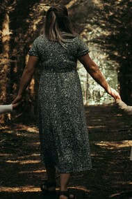 Hand in hand, they move forward — a quiet moment of safety and belonging beneath the trees