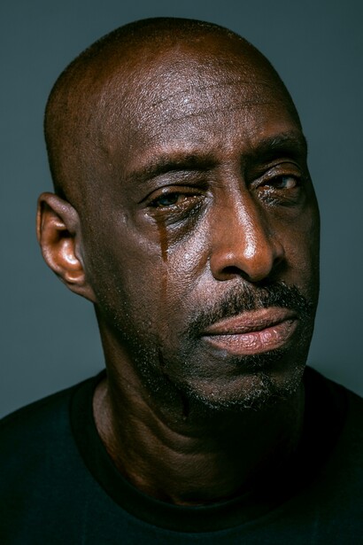 Man allows for tears to fall down his face