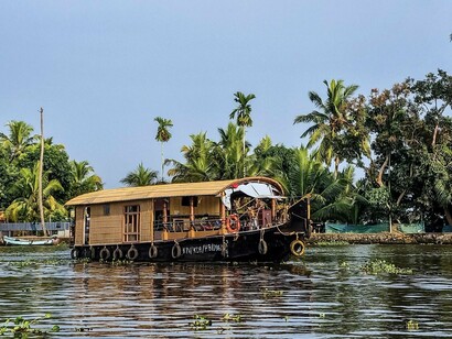 Traditional Kerala houseboats gliding through the calm backwaters in Alappuzha, Kerala, reflecting the unhurried rhythm and cultural heritage of life on the water