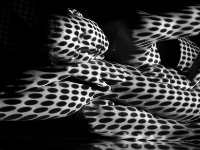 The depiction of a nude woman with black and white zebra stripes represents the themes of darkness and light, highlights human connection, and immerses in surrealism