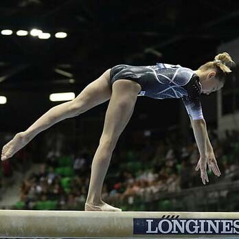 A female gymnast on the balance beam