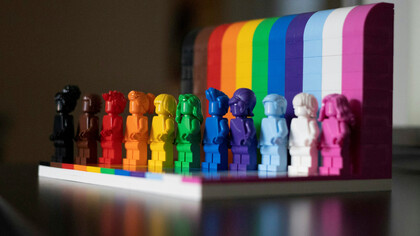 A collection of multi-colored plastic blocks arranged on a white wooden table, featuring the "Everyone is Awesome" Pride Month, celebrating inclusivity and diversity