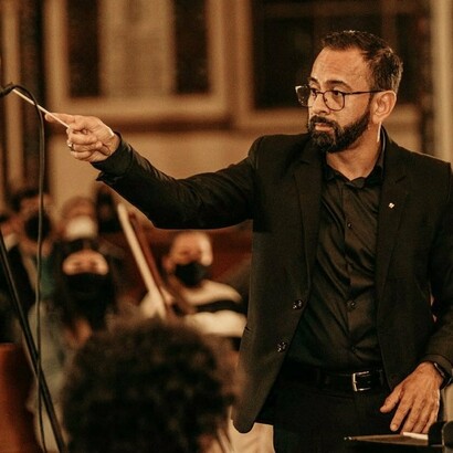 Berny Siles dirigiendo al coro y la orquesta durante la presentación de su misa de réquiem