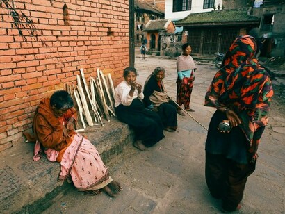 A group of homeless women gathered on a city street, symbolising the collective vulnerability created by the global housing crisis