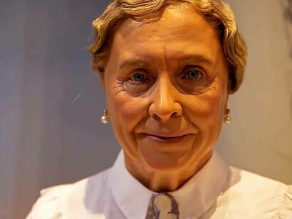 Helen Keller dressed in a white shirt wearing pearled earrings looking elegant and dignified