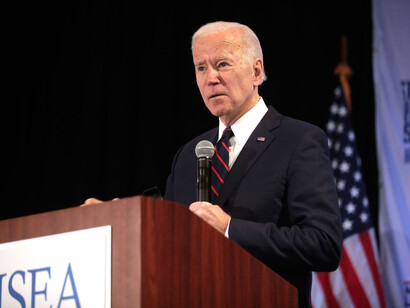 Joe Biden talking at press conference, holding a microphone
