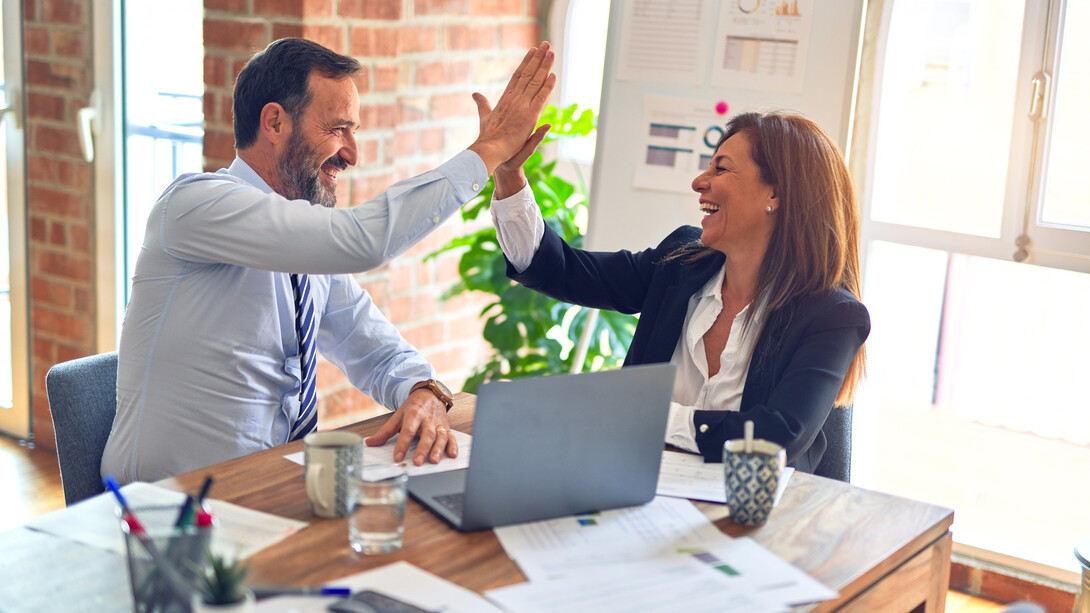 Two business executives high-five in support of one another