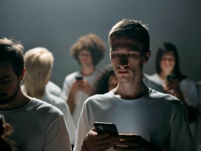 Un homme complètement perdu dans son téléphone, en train d'envoyer des SMS à quelqu'un et de parcourir les réseaux sociaux