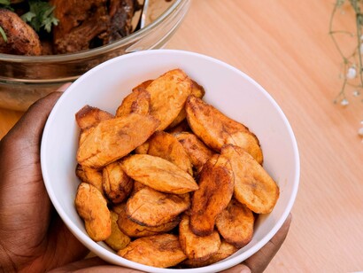 A man holding a bowl of delicious and sweet foods from Africa