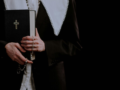 Religiosa llevando en las manos su Biblia y rosario