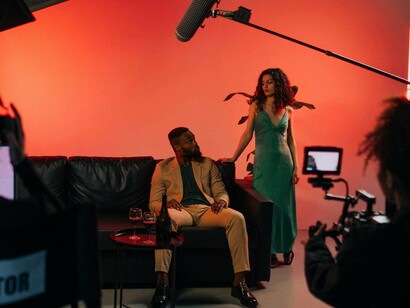 Actors performing under cinematic lighting on a small film set, representing the creative ambition of independent filmmaking