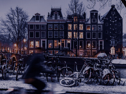 Bicycles along a snowy canal street in Amsterdam, Netherlands