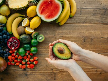 Person holding a freshly sliced avocado