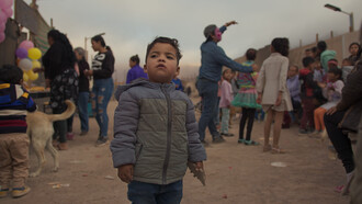 Children's Day celebration at La Mula land occupation. A child looks at the horizon, Chile