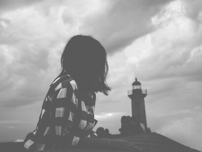 Una chica observa a lo lejos un misterioso faro en Porto, Portugal