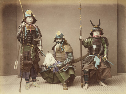 Samuráis en armadura, impresión en plata a albúmina coloreada a mano por Kusakabe Kimbei. Imperio de Japón. La persona de la izquierda tiene un yumi (arco japonés), la del centro tiene una katana y la de la derecha lleva un yari (lanza de punta recta)
