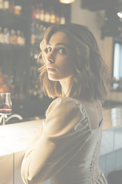 Donna al bar. Una donna di rara bellezza sembrava emanare una luce intrinseca distaccata dallo sfondo