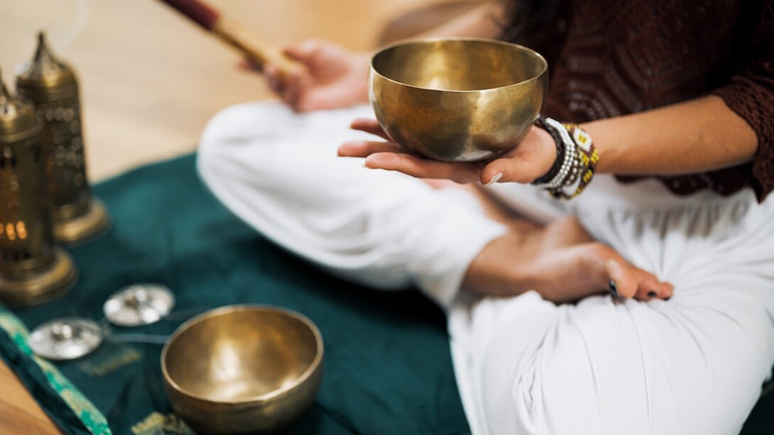 A person in a white shirt delicately holds brown wooden chopsticks, resonating with the harmonizing frequencies of solfeggio