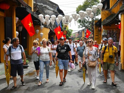 International visitors exploring a lantern-filled historic street in Vietnam, representing the role of travellers as informal ambassadors of their countries