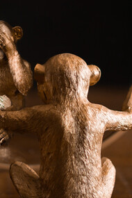 Primata de madeira cobre e mostra os olhos 