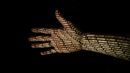 Una mano en la que se refleja el código binario