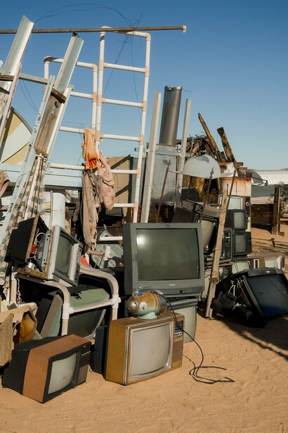 A growing pile of discarded televisions and obsolete electronics, representing the mounting global challenge of electronic waste