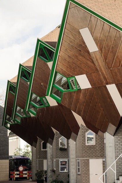 Piet Blom first designed the Cube Houses in Helmond, beginning with three and expanding to 18 stilt houses. He later used the same design in Rotterdam. The houses originally connected to Theater 't Speelhuis, lost to a fire in 2011