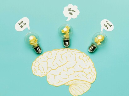 Illustrazione di un cervello straripante di idee in diverse lingue