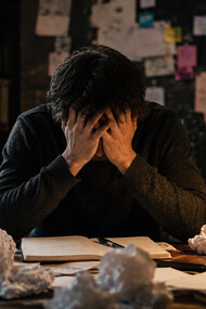 A writer consumed by pressure and self-doubt, highlighting the emotional strain of creating in a noisy world