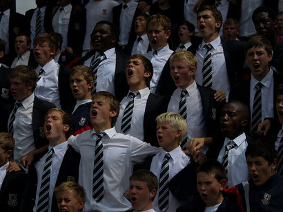 Students in an only boys' school, united in a team, screaming and cheering together, motivating each other to achieve greatness and success
