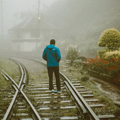 On a foggy morning in Sri Lanka, a lone man walks along the train tracks—his solitude echoing heartbreak and the ache of being misunderstood