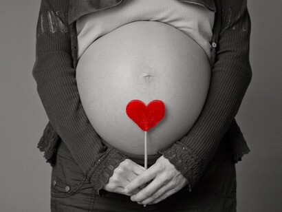 Una embarazada con un corazón sobre su vientre