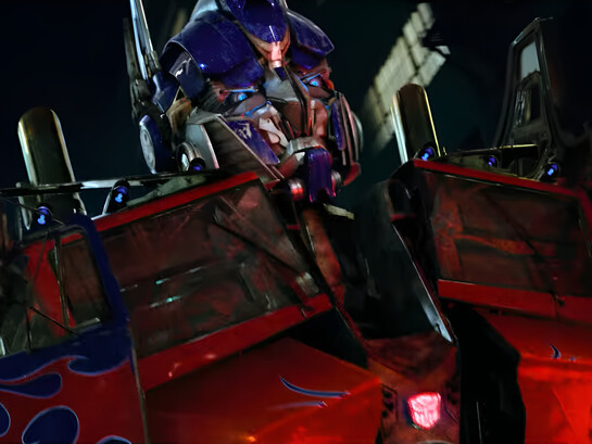 Optimus Prime revealing his imposing robotic form to Sam Witwicky, representing the larger-than-life spectacle and tactile detail of Transformers (2007)