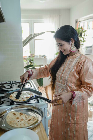 An Indian mom cooking in a small kitchen