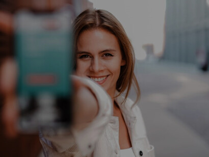 As a social media manager in action, a woman in a white coat adeptly handles her phone