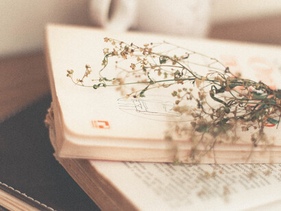 Libro de poesía y libreta de apuntes con un ramillete