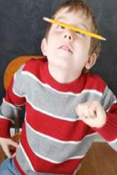 Un niño juega con un lápiz en clase