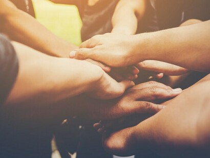 Teamwork in action, with hands joined in solidarity, reflecting the collective struggle for peace