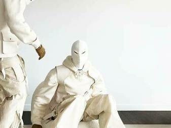 Two people wearing white masks and cream-colored clothing and displaying it on social media