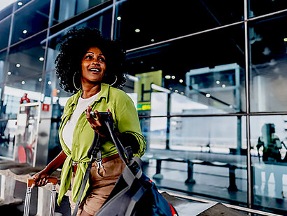 Portrait of a mid-adult woman standing at an airport curbside while waiting for a taxi